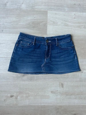 Blå Mini Skirt VGS Y2K Jeanskjol Embroidery  - Mycket fin kjol i blå färg. Kjolen är i mycket bra skick och sparsamt använda. |  Äkta som allt annat jag säljer! ✅ |  Storlek: L / 40  | Skick: Mycket Bra Skick - tyvärr en liten fläck men inget tydligt (SE SISTA BILD)  | Färg: Blå | Märke: VGS | Modell: Kjol |   Hör gärna av dig vid frågor så svarar jag så fort jag kan! 😁 |