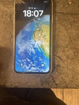 iPhone XR  - Säljer en iPhone med svart framsida och rundade hörn. Telefonen har en stor skärm och klassisk Apple-design med glas på framsidan och metallram. Perfekt för dig som gillar snygg och modern teknik från Apple.