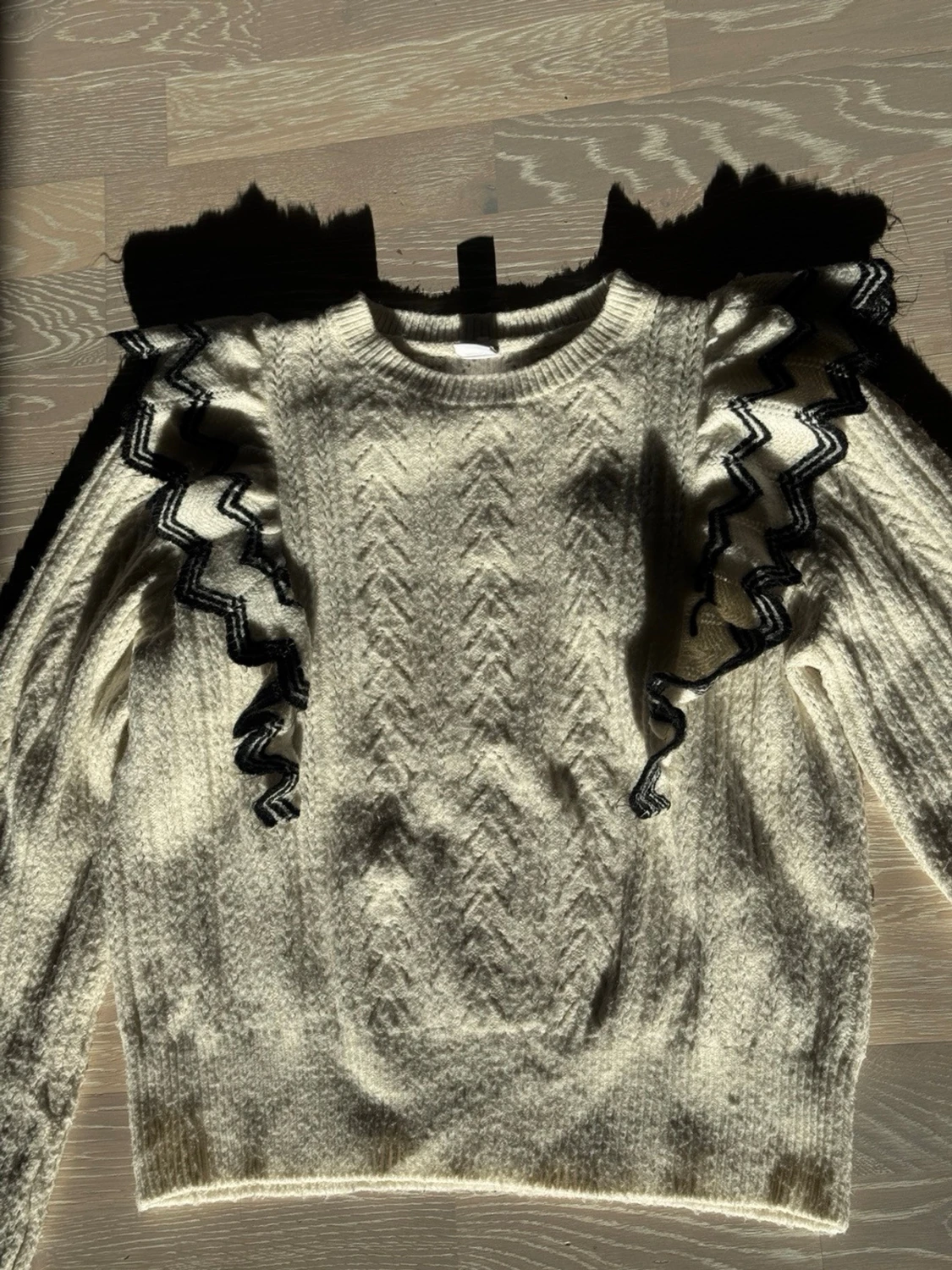 Vit stickad tröja med volangdetaljer