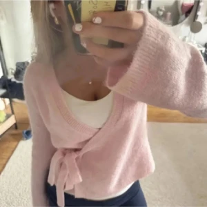 Ljusrosa omlottkofta med knytband - Supersöt ljusrosa stickad omlottkofta från Gina, i storlek 170 så passar s typ. Knappt använd så i väldigt bra sick💗