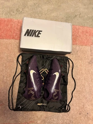 Nike Mercurial fotbollsskor  - Säljer dessa snygga Nike mercurial air zoom vapor 16 elite Mbappe edition, skorna är knappt använda inte mycket alls, dobbarna är lite lite slitna bara annars allt är som nytt nästan, säljer dessa nu då jag inte kommer ha någon användning av dem då jag har åkt på korsbandsskada så nu väljer jag att sälja dem då jag kommer vara borta från fotbollen ett tag och väljer istället att tjäna pengar på dem istället att dem ska bara ligga där, pris kan diskuteras!! Tveka inte att skriva!!
