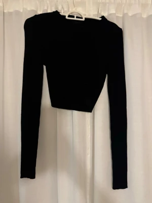 Svart croppad långärmad topp - Trendig svart croppad topp med långa ärmar och rund hals. 