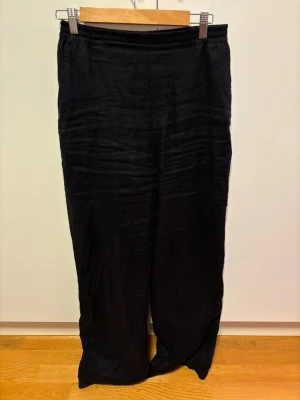 Svarta vida linnebyxor Lindex Bella stl 36 - Säljer ett par svarta linnebyxor med avslappnad passform och resår i midjan. Byxorna har raka ben och är tillverkade i ett mjukt linnetyg som ger en skön och luftig känsla. Perfekta för en chill och stilren look.