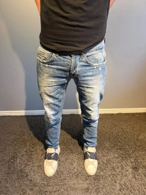 Dondup jeans - Säljer ett par trendiga Dondup jeans med snygga slitningar och tvättade detaljer. De har en slim passform. Storlek 31. Modellen på bilden är 184.