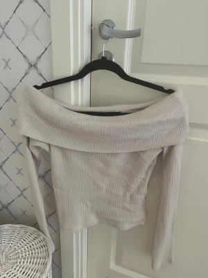 Beige offshoulder topp Gina Tricot - Snygg ribbad offshoulder topp från Gina Tricot i beige.