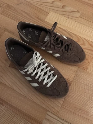 Adidas Spezial bruna sneakers - Bruna Adidas Spezial sneakers i mocka med klassiska vita ränder på sidorna och gummisula. Använd 4 gånger endast och allt tillbehör tillkommer till skorna. 