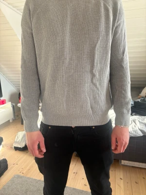 Stickad tröja - Grå ribbstickad tröja från Zara i storlek L. Stilren och tidlös modell med rak passform som funkar lika bra till jeans som till mer uppklädda looks. Mjuk och bekväm kvalitet med fin struktur som ger ett snyggt fall.  Perfekt basplagg i garderoben – enkel att matcha och passar året runt. I fint skick.
