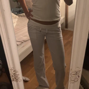 Vita mjukisbyxor Juicy Couture - Säljer ett par vita mjukisbyxor från Juicy Couture i supermjuk velour. Byxorna har dragsko i midjan, raka ben och en ficka framtill. Perfekta för chill dagar och riktigt skön passform.