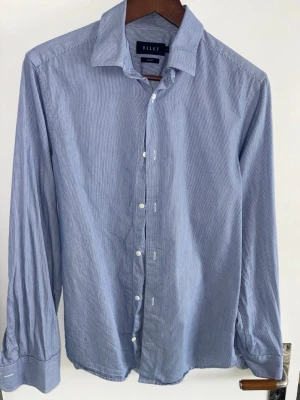 Riley slim fit skjorta herr  - Tjaba, säljer denna blåvitrandiga herr skjorta från Riley. Stilren skjorta i hög kvalité, fortfarande i perfekt skick! Nypris 1200. Används inte längre pga den är för liten! Priset är såklart diskuterbart! 