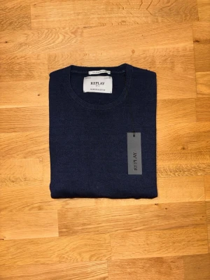 Mörkblå stickad tröja Replay - Tjena! Säljer nu denna helt nya mörkblåa stickade tröja från Replay i storlek L.  Tröjan är oanvänd och kommer med original prislapp kvar.  Modellen är stilren med rund hals, perfekt till både vardag och mer uppklädda tillfällen. Väldigt fin passform och hög kvalitet som Replay är kända för.   Märke: Replay  Storlek: L Skick: Helt ny (med tags) Färg: Mörkblå Nypris: 1100 kr Mitt pris: 649 kr Hör gärna av dig vid frågor eller om du vill ha fler bilder!