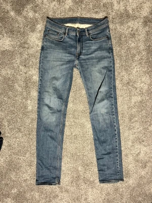 Acne studios jeans - Snygga blå slim fit jeans med klassisk femficksdesign och dragkedjegylf. Jeansen har en tvättad look med lätt slitningar och kontrastsömmar. Perfekta för en avslappnad stil och passar till det mesta. Materialet är denim i bomull.De är lagade i skrevet