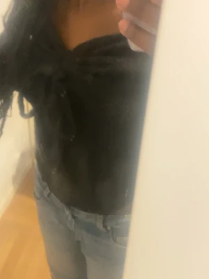 Svart långärmad topp med snörning - Snygg svart långärmad topp med v-ringning och snörning framtill som ger en cool detalj. Toppen är figurnära och passar perfekt till jeans eller kjol. Mjuk och stretchig känsla, superenkel att styla till olika looks.