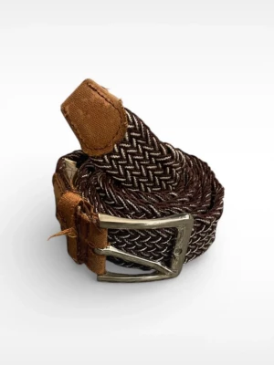 Brunt flätat bälte med läderdetaljer 115cm - Snyggt brunt flätat bälte med vita inslag och detaljer i brunt skinn. Bältet har ett klassiskt metallspänne och passar perfekt till jeans eller chinos. Flätad design ger en avslappnad men ändå stilren look.
