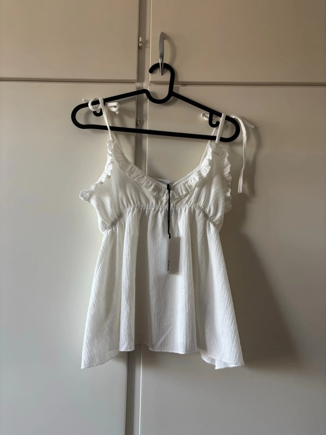 Vit linnetopp med volangdetaljer