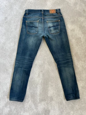 Blå Nudie jeans - Säljer nu mina Nudie jeans med sjukt feta fades. Jeansen är i prima skick och har en lite mer loose passform. Perfekt för archive stilen😍. Hör av dig vid minsta fråga 🤝