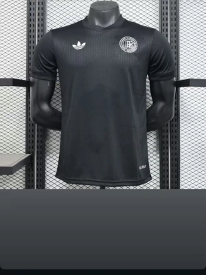 Svart Adidas fotbollströja - Snygg svart fotbollströja från Adidas med diskret randigt mönster. Tröjan har rund hals, korta ärmar och vita loggor på bröstet. Tillverkad i ett lätt och ventilerande material som passar perfekt till träning eller match.