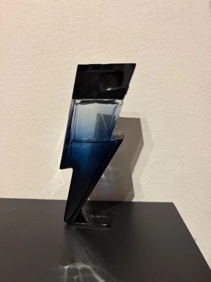 Carolina Herrera Bad Boy parfym - Cool parfymflaska från Carolina Herrera formad som en blixt, i svart och mörkblått glas. Flaskan har en modern och edgy design som verkligen sticker ut på hyllan. Perfekt för dig som gillar unika detaljer och vill ha något extra i din samling.