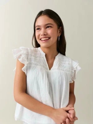 Vit blus från Gina Young  - Söt vit blus från Gina Young med volangprydda korta ärmar och v-ringning. Blusen har tunna spetsdetaljer upptill och är gjord i ett lätt, luftigt tyg som känns som bomull. Perfekt för en fräsch och somrig look. I storlek 158/164! Pris kan diskuteras