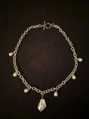 Silverfärgat halsband med pärldroppar gjort i rostfritt stål  - Stilrent halsband i silverfärgad metall med kedja och pärlor. Halsbandet är gjort i rostfritt stål 🙌☀️