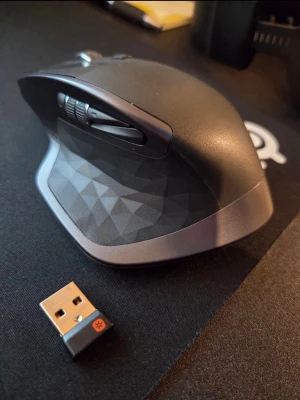 Logitech MX Master trådlös mus - Säljer en Logitech MX Master trådlös mus i svart och grått med ergonomisk design och flera programmerbara knappar. Musen har ett mönstrat sidoparti och levereras med USB-mottagare. Perfekt för både gaming och produktivitet.