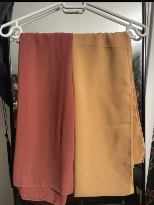 Rosa & Toffee Chiffon Hijab - Säljer två sjalar; en korallrosa och en toffee färgad. Rosa sjalen har använts många gånger och toffee sjalen har aldrig använts. Båda är i mycket bra skick.   En för 30kr, båda för 50kr.
