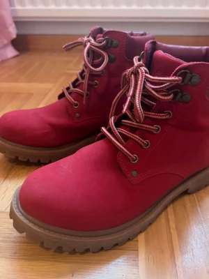 Röda kängor/boots med grov sula - Priset går att diskutera 🫶Säljer ett par snygga röda kängor med grov gummisula och matchande röda snören 🔥 Kängorna har metallhål för snörningen och vadderad kant upptill för extra komfort 🌷Perfekta för dig som vill sticka ut med färg i höst och vinter 🪩