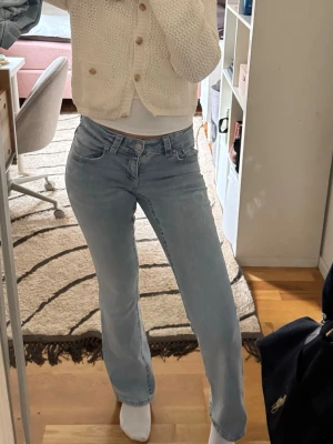 Ljusblå bootcut jeans - Snygga ljusblå jeans med rak passform och klassisk femficksdesign. Jeansen har normal midja och är tillverkade i denim med en lätt tvättad look. Perfekta för en avslappnad och trendig stil.