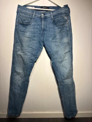 Ljusblå jeans från Replay - Snygga ljusblå jeans från Replay med raka ben. Jeansen har diskreta slitningar och detaljerade sömmar på bakfickorna. Tillverkade i mjuk denim som ger en grymt stilren men skön passkänsla. 