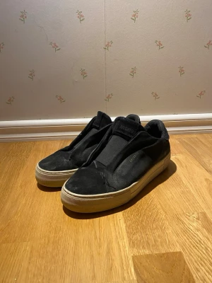 Svarta arigato laceless från Axel arigato - Säljer ett par Svarta axel arigato laceless. Jag säljer de för att de är för små för mig, dom är smutsiga på bilden men det går att tvätta.