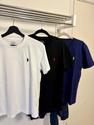 3-pack Polo Ralph Lauren t-shirts - Säljer ett 3-pack t-shirts från Polo Ralph Lauren i vitt, svart och marinblått. Storlek Custom Slimfit Medium på samtliga. Endast provade och tvättade, absolut nyskick!  450kr för alla 3 eller 200kr styck om man bara vill köpa en. 