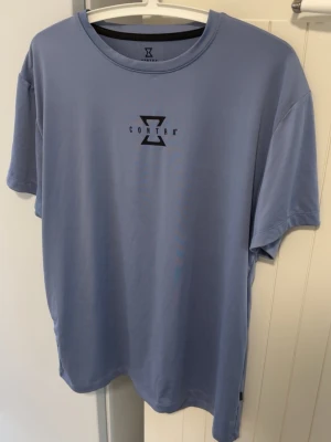 Tränings T-shirt  - Ljusblå Contra T-shirt i polyester perfekt för träning och vardagen. Tröjan knappt använd. Storlek på tröjan Medium men sitter som Large
