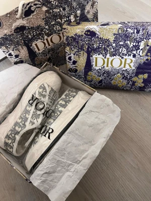 Dior sneakers  - Säljer ett par helt nya  superfina Dior WALK’N sneakers. Modellen är med lite högre sula. Låda och bag medföljer. Storlek 40 men ganska små, de är en klar 39a. Pris går att diskutera, hör av er vid frågor och intresse.