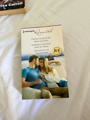 Harlequin Romaner 3-i-1 - En pocketbok från Harlequin Romaner med tre romantiska berättelser: 'Alltid i mitt hjärta' av Diana Hamilton, 'Under bar himmel' av Barbara Hannay och 'Ingen återvändo' av Miranda Lee. Omslaget har en bild på ett par i en kärleksfull scen.