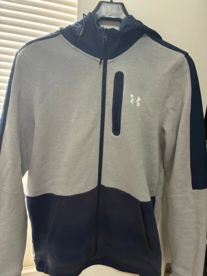 Under Armour Kofta - Säljer min sällsynta Under Armour kofta som ej säljs längre, koftan är lite solbränd vid den blåa delen runt midjan som i bilden syns. Utöver det är koftan i mycket bra skick utan defekter
