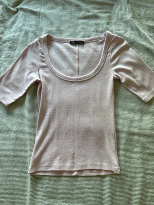 Ljusrosa topp från Zara - Supersöt ljusrosa t-shirt från Zara med hyfsat djup urringning och lite längre armar. Har använt den en gång