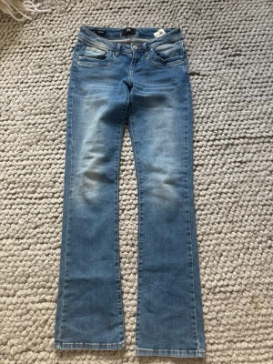 Blå bootcut jeans från LTB - Snygga blå bootcut jeans från LTB med väldigt låg midja och lätt slitning. Jeansen är tillverkade i stretchigt denim för en bekväm passform. Perfekta för en avslappnad och trendig look.