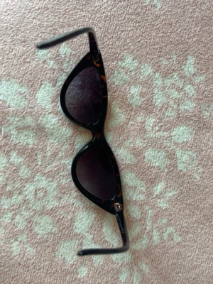Bruna cat eye solglasögon - Snygga cat eye solglasögon med brunmelerad båge och mörka glas. Den klassiska formen ger en retrovibe och bågen har ett leopardinspirerat mönster. Perfekta för att lyfta vilken outfit som helst.