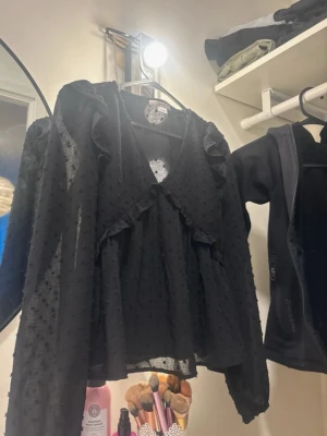 Svart blus med volanger från Gina  - Trendig svart blus, från Gina tricot i strl 146/152