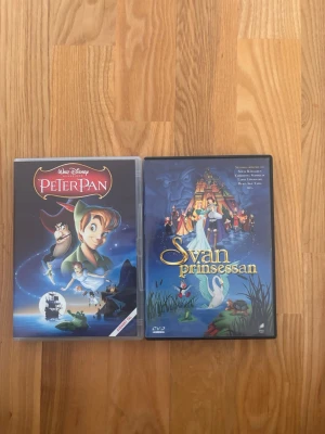 Peter Pan & Svanprinsessan DVD-filmer - Två klassiska animerade filmer på DVD: Disneys Peter Pan och Svanprinsessan. Omslagen är färgglada med motiv från filmerna och fodralen är i plast. Perfekt för dig som gillar tecknade äventyr och sagor.