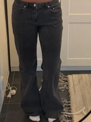 Svarta utsvängda jeans - Snygga svarta jeans med utsvängda ben och klassisk femficksdesign. Jeansen har låg midja och raka sömmar, perfekta för en trendig och avslappnad stil. Passar till många olika outfits och är ett måste i garderoben.