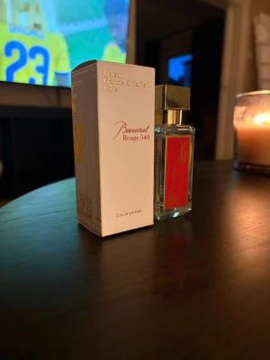 Baccarat Rouge 540 Eau de Parfum - Exklusiv parfymflaska från Maison Francis Kurkdjian, Baccarat Rouge 540. Flaskan är genomskinlig med en röd etikett och har en elegant guldfärgad fyrkantig kork. Kommer i en vit och guldig kartong med stilren design. En ikonisk doft för dig som gillar lyx. Flaskan är så gott som full