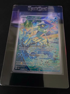 Pokémonkort Frogadier holo - Säljer ett Pokémonkort med Frogadier-motiv, holofoil och färgstark design. Kortet är inplastat i en RankCard-sleeve för extra skydd. Perfekt för samlare eller Pokémonfans som vill utöka sin samling.
