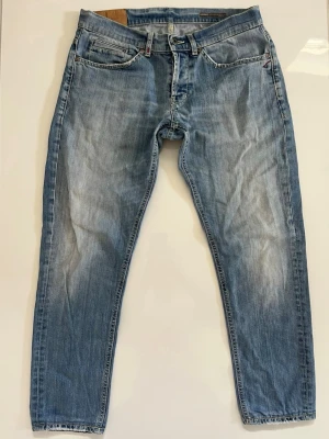 Dondup George jeans - Säljer ett par ljusblå jeans med raka ben och diskreta slitningar framtill. Jeansen har klassisk femficksdesign, bälteshällor och dragkedjegylf. Materialet är denim i bomull och passformen är avslappnad men ändå snyggt smal.