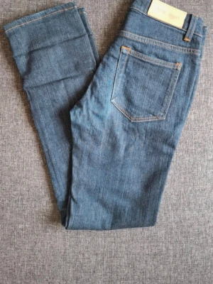 Blå raka jeans från Acne Studios - Säljer ett par klassiska blå jeans från Acne Studios med raka ben och hög midja. Jeansen har fem fickor, kontrastsömmar och en läderpatch med logga bak i midjan. Perfekta till en avslappnad stil och tillverkade i slitstark denim.