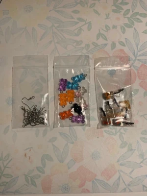 DIY örhängeskit med pärlor och krokar - Säljer ett kit för att göra egna örhängen! Innehåller örhängeskrokar (nickelfria), färgglada nallebjörnar i olika färger samt små drickor i olika färger. Perfekt för dig som vill skapa unika smycken själv. Allt kommer i små plastpåsar. 💗 Jag säljer även små packpåsar som du hittar i min profil💗