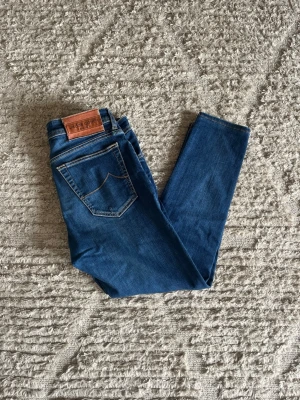 Jacob cohen jeans  - Säljer nu dessa populära BARD Jacob Cohen jeans i en fin blå färg. Storlek är w33. Inga skador eller defekter 9/10. Midja:43cm. Lår:24cm. Ytterlängd:92cm. Innerlängd: 67cm