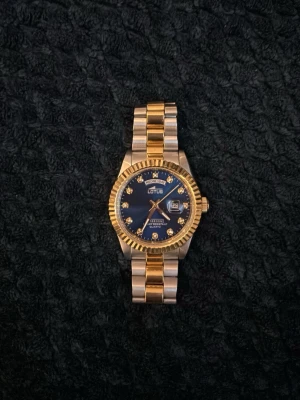 Guld- och silverfärgad Lotus klocka -  Box finns. Det finns även fler länkar som medföljs. Inga repor. Nyköpt knappt använd. Bra pris snabb affär!