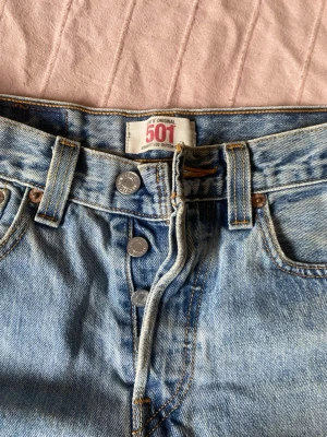 Levi's 501 ljusblå jeansshorts stl 28/30 - Avklippta Klassiska Levi's 501 jeansshorts i ljusblå denim med knäppning framtill litet hål enligt bild 