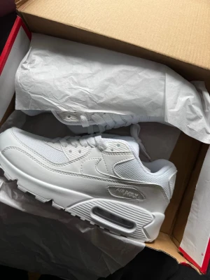 Nike Air Max 90 helvita sneakers - Nike Air Max 90 sneakers i helvitt med klassisk siluett. Säljer dessa då jag råkade ta fel storlek på dom. Dom är helt oanvända och i nutt skick. Bara att höra av er vid funderingar