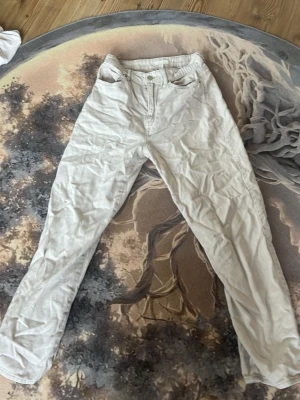 Vita raka jeans från H&M - Säljer ett par vita jeans från H&M i storlek 34. De har rak passform, klassisk femficksdesign och normal midja. Materialet är bomull med en mjuk känsla. Perfekta för en clean och stilren look.